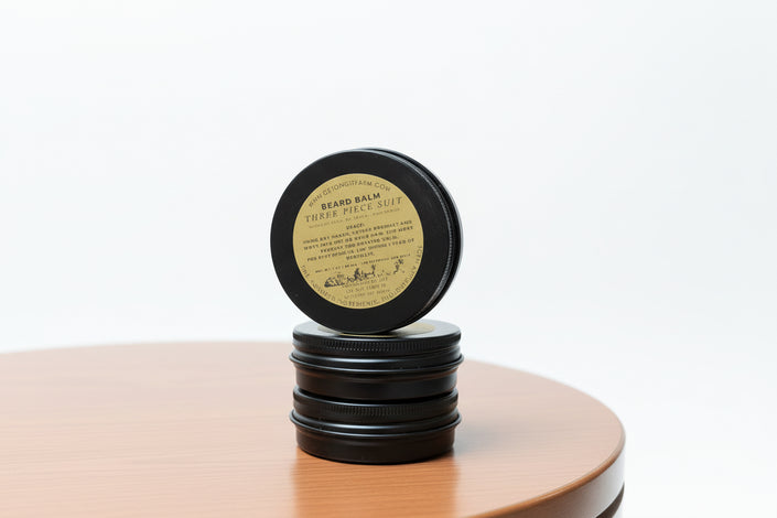 Stack of black containers with a label on a wooden surface