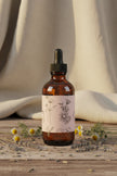 Amber glass dropper bottle with a floral label on a white background